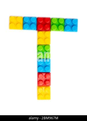 Buchstabe T des englischen Alphabets von mehrfarbigen Kinder-Plastikkonstruktor auf einem weißen isolierten Hintergrund. Helles Alphabet für Kinder Design Stockfoto