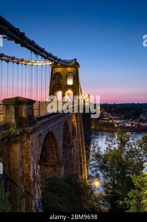 Telfords Menai Suspension Bridge über die Menai Strait in der Nacht, Anglesey, North Wales, Großbritannien Stockfoto