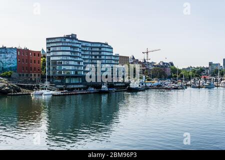 VICTORIA, KANADA - 14. JULI 2019: Geschäftiger Hafen in der Innenstadt mit Yachten und modernen Gebäuden. Stockfoto