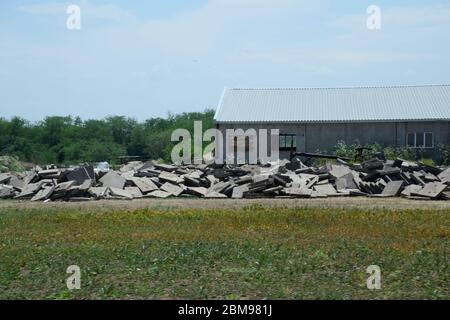 Stapel von Betonplatten, die in der Nähe des alten Gebäudes aufstapelt sind. Stockfoto