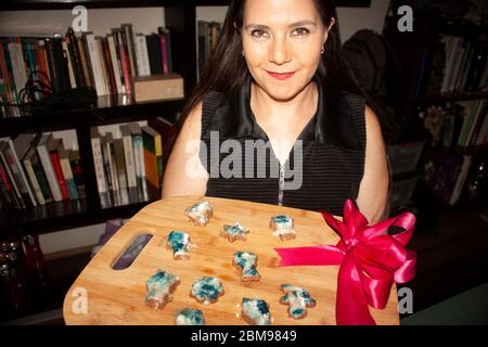 Kaukasische Frau mit honigfarbenen Augen hält in den Händen Geschenk Tablett mit Lebkuchen in Sternformen geschnitten, buo, Katze, Blume Lebkuchen Mann Stockfoto