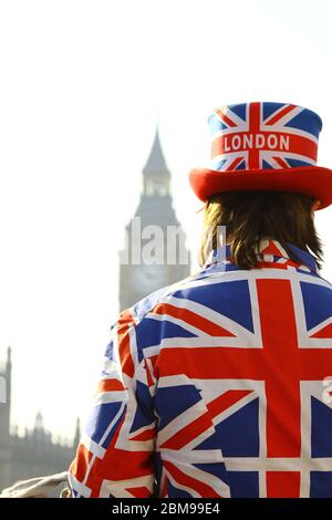 Symbole von London, England und Großbritannien mit dem ikonischen Uhrturm Big Ben Elizabeth im Hintergrund und einem Mann, der die Flagge der Union Jack trägt, um den britischen Tourismus zu fördern. Russell Moore Portfolio-Seite. Stockfoto