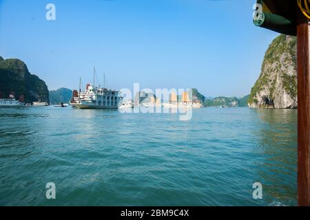 Halong Bay Vietnam - Oktober 23 2013; Dschunken und Touristenboote in schönen dramatischen und ruhigen Morgenlicht beliebtes Reiseziel in Vietnam. Stockfoto