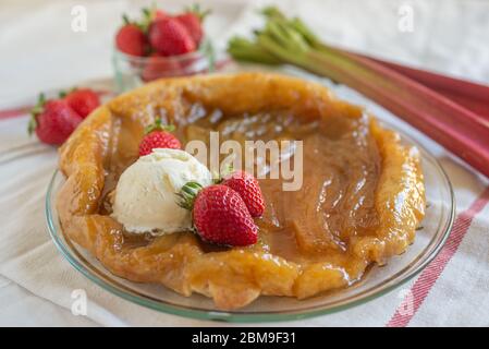 Rhabarber umgedrehten Kuchen mit Erdbeeren und Eis Stockfoto