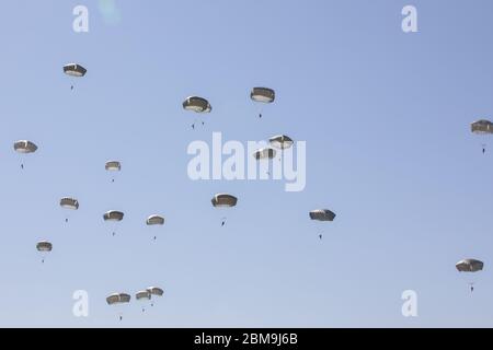 Fallschirmjäger der 82. Luftlandedivision steigen nach einem Sprung aus einem Flugzeug während eines Flugbetriebs auf Fort Bragg, NC, 7. Mai 2020 ab. Die Airborne Operation markiert die Rückkehr der 82nd Airborne Division zu begrenzten Trainingseinheiten unter Einhaltung von Gesundheits- und Sicherheitsrichtlinien, um die Ausbreitung des neuartigen Coronavirus zu verhindern. Fallschirmjäger mussten Masken tragen, während sie sich in unmittelbarer Nähe befanden, und Jumpmasters trugen Masken, während sie Inspektionen im Passagierterminal durchführten. (USA Armeefoto von Sgt. Klasse Zachary J. VanDyke) Stockfoto