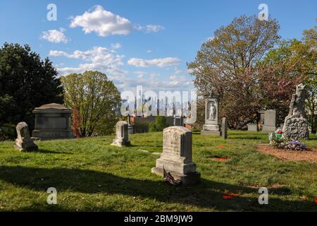 New York, New York, USA. Mai 2020. Gräber vor der Skyline von Manhattan und dem Freedom Tower auf dem Greenwood Cemetery in Brooklyn, New York City, USA. New York City ist das Epizentrum der Coronavirus-Pandemie Kredit: William Volcov/ZUMA Wire/Alamy Live News Stockfoto