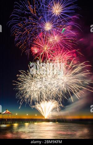 Farbenfrohe Silvestergarben-Feuerwerke leuchten den Himmel und das Wasser vor Brighton Jetty, Adelaide, South Australia Stockfoto