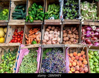 Eine Auswahl an frischem Obst und Gemüse in Kisten verpackt zum Verkauf am Straßenrand in der Bergstadt Imlil in Marokko. Stockfoto