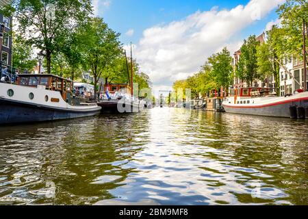 Wasserstand Blick von einem Boot im Herbst zu einem Wohngebiet Kanal mit Yachten und Hausboote in Amsterdam, Niederlande. Stockfoto