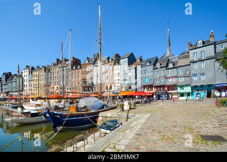 Malerischer und malerischer mittelalterlicher Hafen im Normandie-Dorf Honfleur France mit Booten, Segelbooten, Cafés und Touristen, die die Küstenstadt einkaufen Stockfoto