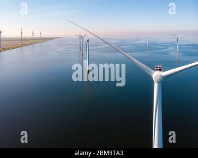 Windturbine aus der Luft, Drone Blick auf den Windpark westermeerdijk ein Windmühlenhof im See IJsselmeer der größte in den Niederlanden, nachhaltig Stockfoto