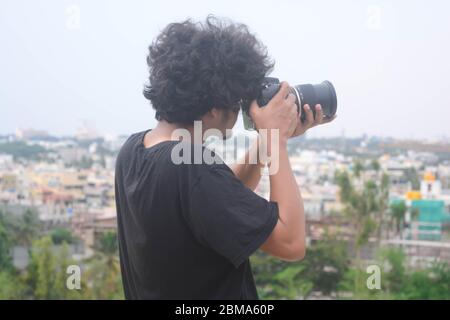 Ein junger Fotograf, der Fotos von der Stadt während der Corona-Sperrzeit. Stockfoto