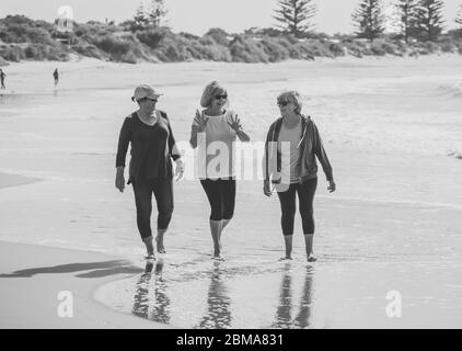 Schöne Gruppe von drei aktiven älteren Frau auf ihren 60ern zu Fuß, Sport und Spaß am Strand. Reife Frauen lachen genießen Spaziergang auf Vacat Stockfoto