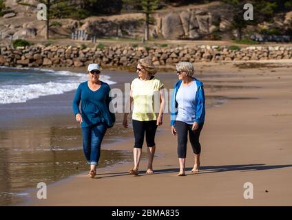 Schöne Gruppe von drei aktiven älteren Frau auf ihren 60ern zu Fuß, Sport und Spaß am Strand. Reife Frauen lachen genießen Spaziergang auf Vacat Stockfoto