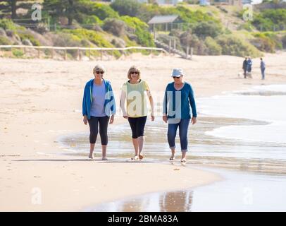 Schöne Gruppe von drei aktiven älteren Frau auf ihren 60ern zu Fuß, Sport und Spaß am Strand. Reife Frauen lachen genießen Spaziergang auf Vacat Stockfoto