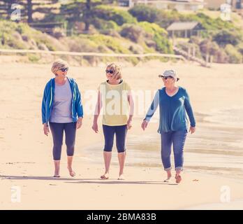 Schöne Gruppe von drei aktiven älteren Frau auf ihren 60ern zu Fuß, Sport und Spaß am Strand. Reife Frauen lachen genießen Spaziergang auf Vacat Stockfoto