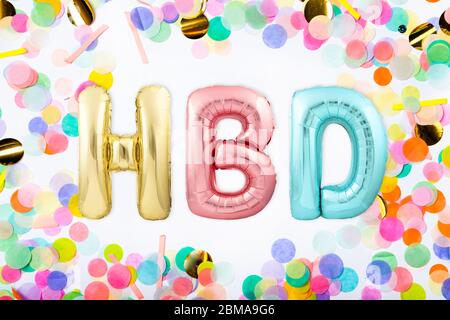 Akronym HBD für HAPPY BIRTHDAY aus bunten aufblasbaren Ballon Buchstaben in einem Rahmen aus bunten Konfetti gemacht Stockfoto