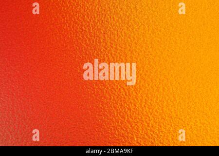 Vertikales Bild. Der Hintergrund ist orange, Schattierung zu einem tiefen Gelb. Sie haben eine raue Oberfläche. Stockfoto