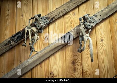 Vintage-Ski hängen an einer Holzwand. Sportgeräte des letzten Jahrhunderts Stockfoto