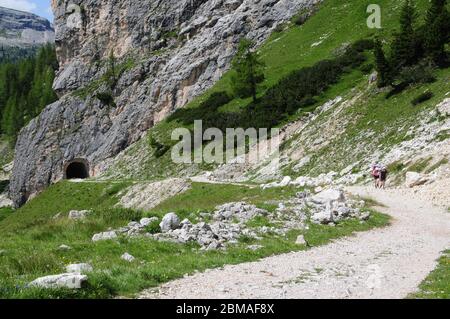 Wanderer auf einer Bergstrecke zwischen Passo Falzarego und Col dei Bos in den italienischen Dolomiten. Die Strecke und der Tunnel stammen aus dem 2. Weltkrieg. Stockfoto