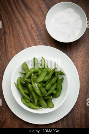 Bio Edamambohnen Snack in Schüssel auf dem Tisch mit Meersalz Stockfoto