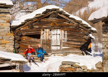 Langläufer, die sich vor der Holzhütte im Nationalpark Gran Paradiso, Valnontey, Aostatal, italienische alpen, Italien, Europa ausruhen Stockfoto