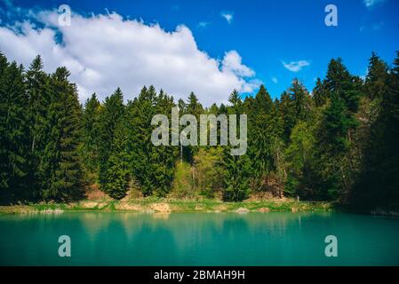 Blauer See, grüner Wald und Himmel im sonnigen Frühlingstag. Banska Stiavnica, Slowakei Stockfoto