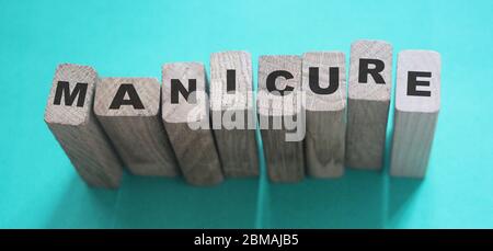Maniküre Wort auf Holzblöcke geschrieben. Konzept der Schönheitsverfahren Stockfoto