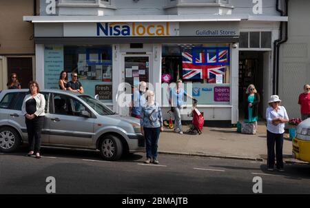 Thaxted, Großbritannien. Mai 2020. Thaxted Essex England. VE Tag 2 Minute Stille zur Erinnerung an den 75. Jahrestag 0f Ende des Zweiten Weltkriegs in Europa. 8. Mai 2020 Einwohner von Thaxted versammeln sich, um sich wegen der Coronavirus-Pandemie außerhalb des Guildhall aus dem 14. Jahrhundert respektvoll voneinander zu distanzieren, um an einer 2-minütigen Stille teilzunehmen, um an diejenigen zu erinnern, die im Zweiten Weltkrieg ihr Leben verloren haben, darunter 11 Männer aus Thaxted, An diesem Tag der 75. Jahrestag des Endes des Krieges in Europa, VE Day, 8. Mai 1945 - 8. Mai 2020. Foto von Credit: BRIAN HARRIS/Alamy Live News Stockfoto