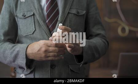 Geschäftsmann mit Desinfektionsmittel oder antiseptischer Flüssigkeit. Nahaufnahme der Hände des Geschäftsmanns mit Flasche Antiseptikum, die wegen einer Pandemie verwendet werden müssen Stockfoto