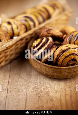 Runde hausgemachte Kekse auf dem Tisch. Gestreifte Kekse mit Kakao und Zimt. Appetitliche Brötchen. Holzhintergrund mit Platz für Text. Essen zu Hause. Stockfoto