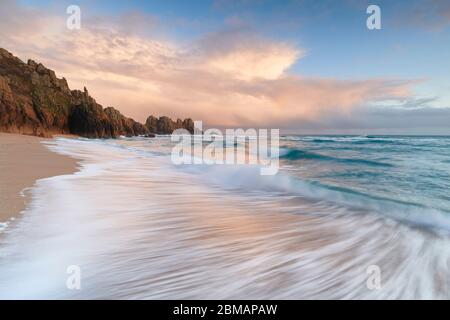 Die Abendsonne beleuchtet die Wolken am Pedn Vounder Strand Porthcurno Stockfoto