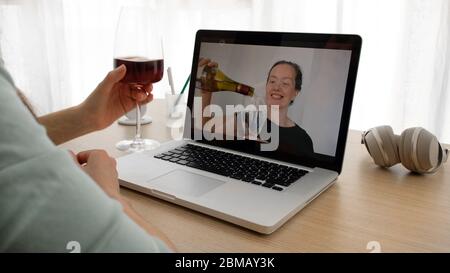 Frauen sprechen auf einer Webcam mit Wein Stockfoto