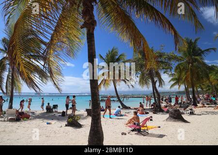 GUADELOUPE, FRANKREICH - 8. DEZEMBER 2019: Die Leute verbringen Strandurlaub in Sainte Anne auf der Insel Guadeloupe. Guadeloupe hat 650,000 jährliche Besucher. Stockfoto