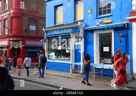 LONDON, Großbritannien - 13. JULI 2019: Besucher besuchen Portobello Road im Londoner Stadtteil Notting Hill. Portobello Road ist bekannt für seinen Sonntagsmarkt und die alte Stockfoto