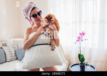 Pillow Challenge zu Hause während der Quarantäneisolation des Coronavirus pandemic. Frau mit Spaß tragen Kissen halten Katze Stockfoto