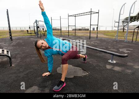 Sportliche kaukasische Frau Training auf dem Spielplatz Stockfoto