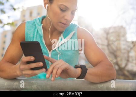 Sportliche kaukasische Frau mit ihrer Smartwatch Stockfoto