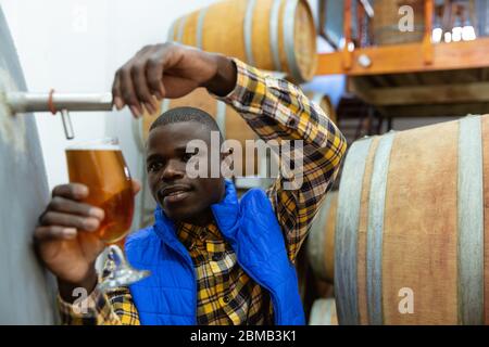 Afroamerikanischer Mann, der in einer Mikrobrauerei arbeitet Stockfoto