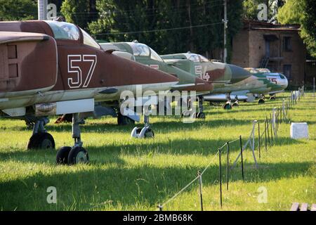 Ansicht der MiGs, die in der Reihe am ukrainischen Luftfahrtmuseum geparkt sind - MiG-27 und MiG-23 im Vordergrund, MiG-21, MiG-19 und MiG-17 im Hintergrund Stockfoto