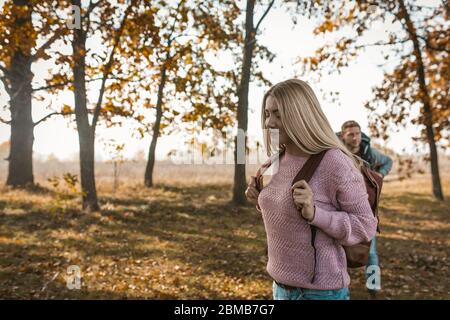 Glückliche Reisende mit Rucksäcken beginnen ihre Reise im Herbst Sonnenwald Stockfoto