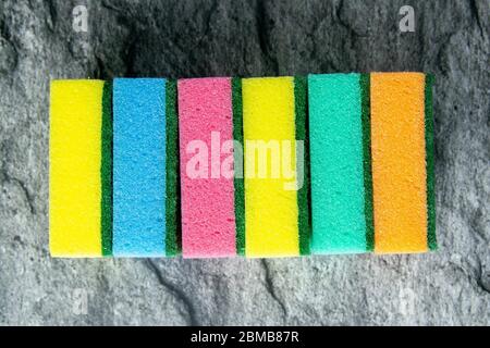 Farbige Schwämme für die Küche auf dem Hintergrund des Tisches in der Farbe von weißem Marmor. Draufsicht, Nahaufnahme Stockfoto