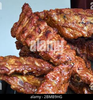 Gegrillte und gegrillte Rippchen Schweinefleisch. Leckere traditionelle amerikanische Fleisch. Rind-und Schweinerippen in BBQ Smoker gekocht.Tasty gegrillten Spareribs in Grill bedeckt Stockfoto