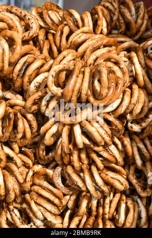 Deutsche Brezeln stapeln sich übereinander, eine Gruppe dünner trockener Brezeln am Seil auf einem Tisch bei einem Lebensmittelmarktfest, traditionelles Essen Stockfoto