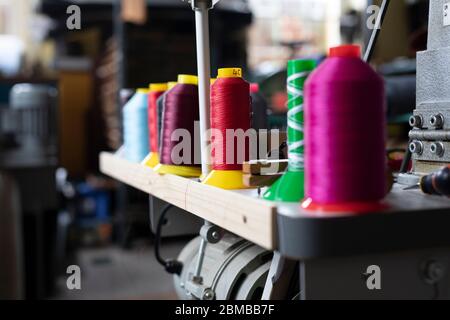 Bunte Baumwollspulen auf einer Nähmaschine. Stockfoto