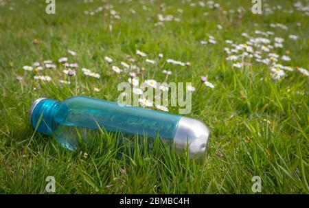 Eine Flasche Wasser, die während der Coronavirus/Covid 19 Pandemie, Mai 2020, auf dem Gras abgelegt wurde. Stockfoto