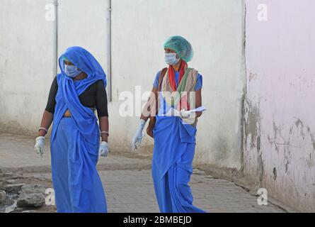 Anganwadi-Arbeiter, die während einer Tür-zu-Tür-Untersuchung, um die Ausbreitung des neuartigen Coronavirus zu überprüfen, eine Schutzmaske und Handschuhe tragen, im Slum-Bereich in Beawar. (Foto von Sumit Saraswat/Pacific Press) Stockfoto