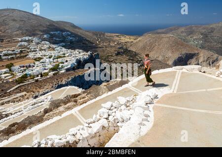 Eine junge Frau, die den Fußweg von der Kirche Panagia, Folegandros, Kykladen Inseln, Griechenland absteigt Stockfoto