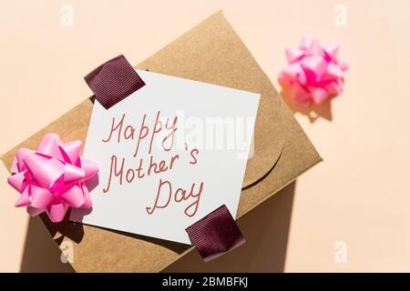 Happy Mothers Day Nachricht mit handgefertigtem Herzen. Muttertag greting Karte.Urlaub Geschenkbox auf pastellfarbenem Hintergrund. Stockfoto
