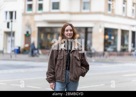 Junge Frau mit echtem Lächeln auf der City Street Stockfoto